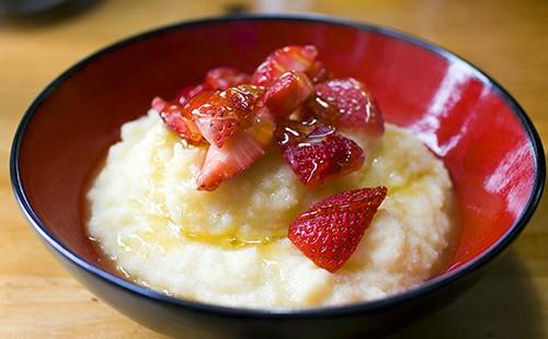 Sinigang na may tinadtad na mga strawberry sa isang madilim na pulang plato