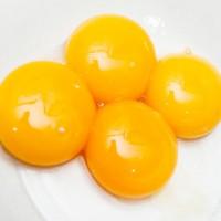 Apat na inihanda yolks sa isang puting plato