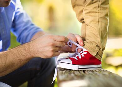 Itinali ni tatay ang mga sapatos para sa kanyang anak