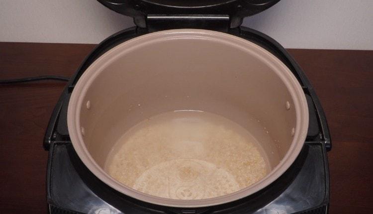 Ibuhos ang tubig sa mangkok ng multicooker, kung ninanais, agad na ibuhos doon ang cereal.