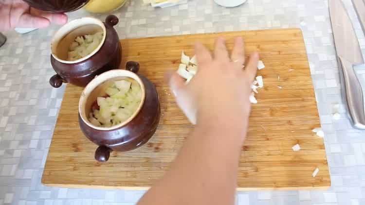 Upang magluto ng karne ng baka sa mga kaldero na may patatas sa oven ilagay ang mga sibuyas