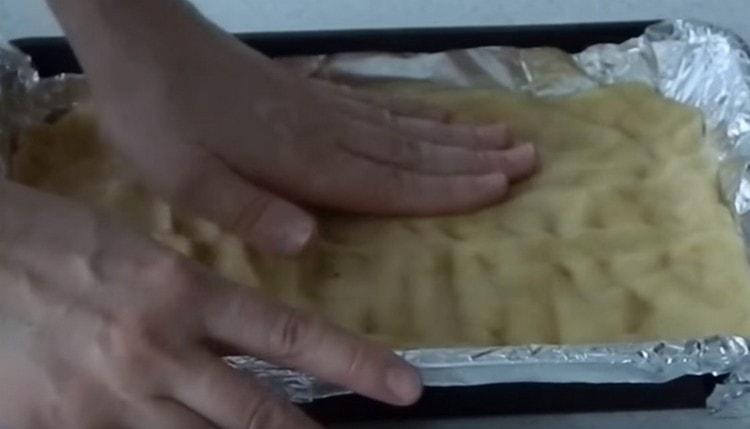 linya ang baking sheet na halos lahat ng kuwarta. paggawa ng maliliit na panig.