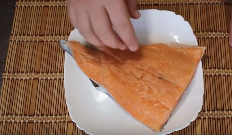 Naghuhugas kami at pinatuyo ang fillet ng salmon, tinanggal ang mga buto sa loob nito.