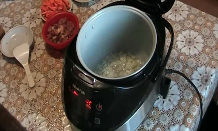 Upang magluto ng pilaf sa isang multicooker Polaris, iprito ang sibuyas