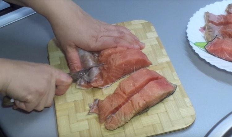 Gupitin ang fillet ng pink salmon.