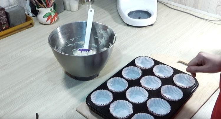 Ipasok ang mga pad ng papel sa cupcake pan.