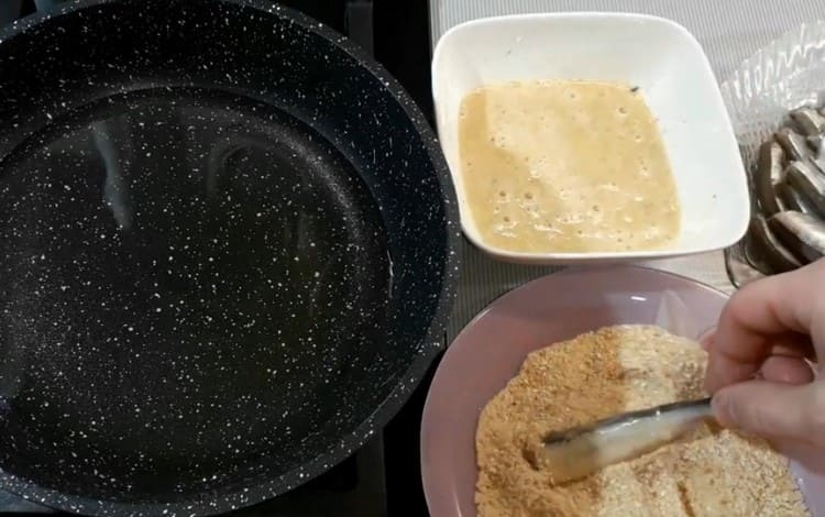 Itusok ang bawat isda sa masa ng itlog, at pagkatapos ay i-roll sa mga breadcrumbs.