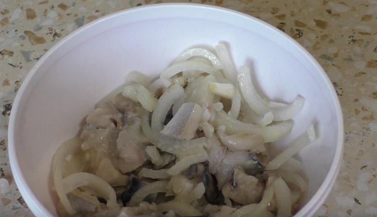 Para sa pagpuno, i-chop ang peeled mackerel sa mga piraso at ihalo ito sa sibuyas na tinadtad sa kalahating singsing.