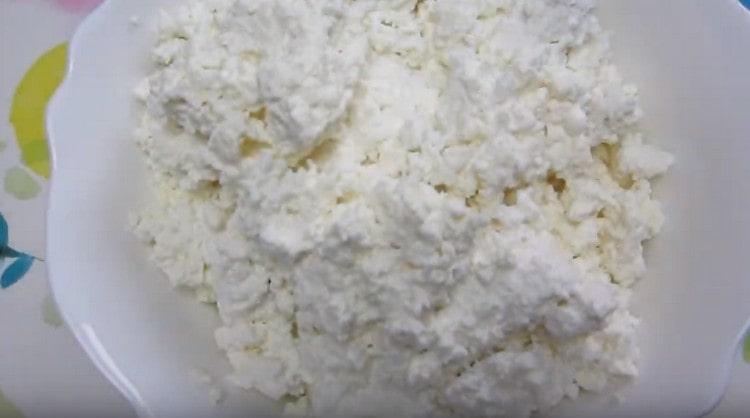 Ilagay ang cottage cheese sa mangkok para sa pagpuno.