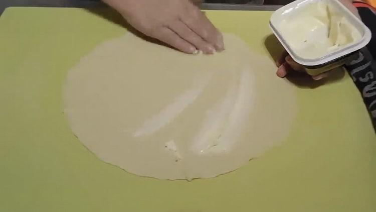 Upang makagawa ng mga flat cake sa tubig, grasa ang kuwarta na may mantikilya