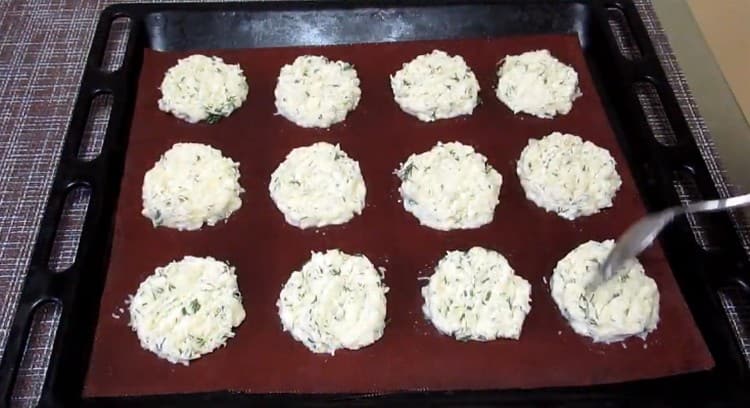 Ikinakalat namin ang masa ng patatas sa isang baking sheet na sakop ng pergamino o isang silicone mat na may isang kutsara.