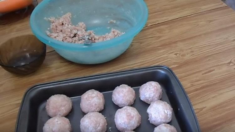 Susunod, bumubuo kami ng mga round meatballs at inilalagay ang mga ito sa isang baking sheet na may mataas na panig.