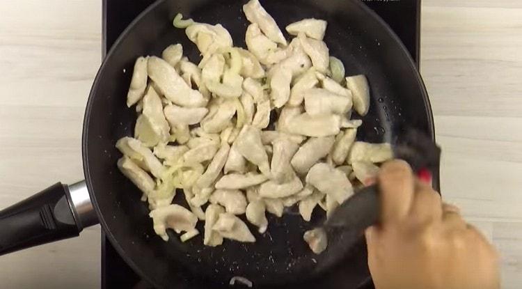 Magdagdag ng sibuyas sa fillet ng manok, ihalo.