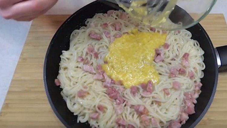 Matapos alisin ang kawali mula sa kalan, idagdag ang masa ng egg-cheese sa i-paste at ihalo.