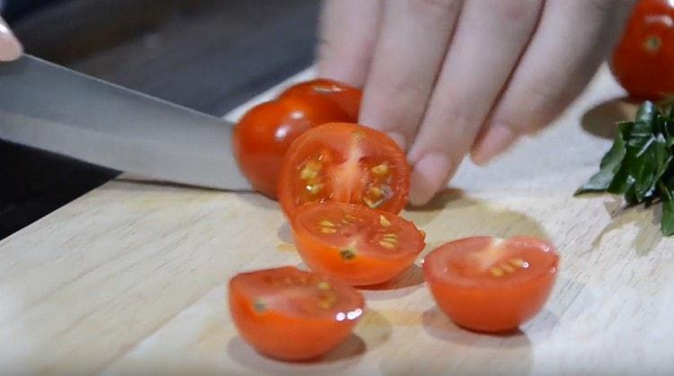 Hatiin ang mga kamatis ng cherry.