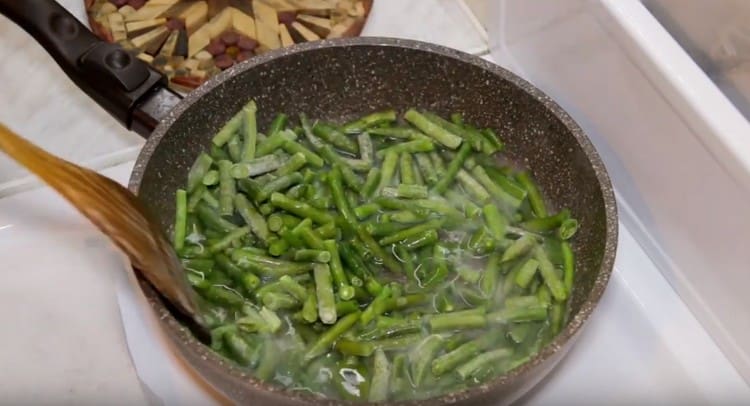 Ang mga bean ay ipinadala sa kawali at magdagdag ng tubig dito.