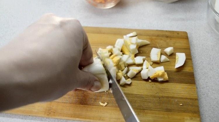 Нарязваме сварените яйца на кубче.