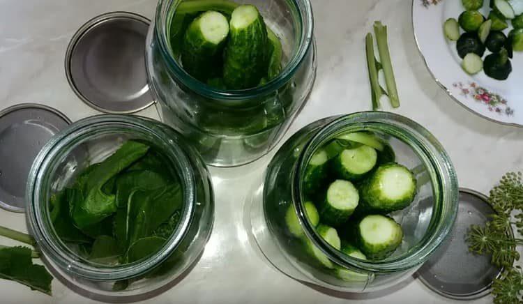 Gupitin ang mga buntot ng mga pipino at patayo na itabi ito sa mga garapon.