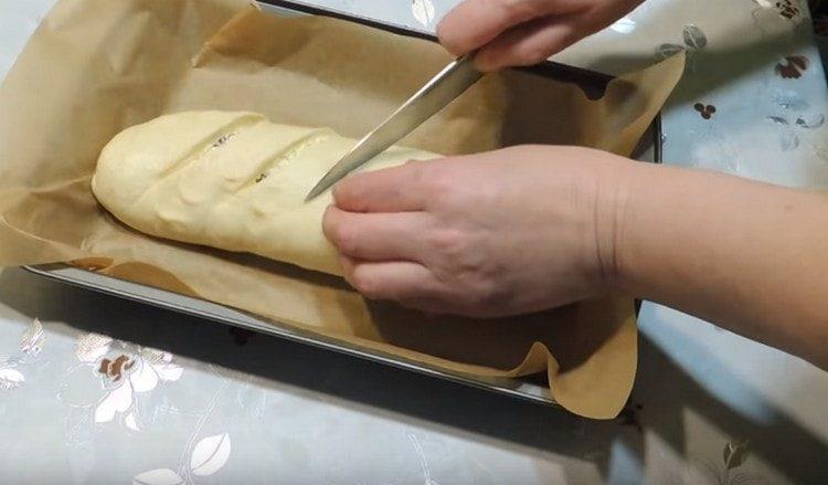 I-twist namin ang kuwarta sa isang roll, ilagay ito sa isang baking sheet, pinutol ito.