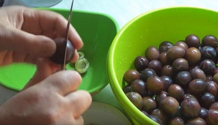 Gupitin ang hugasan na mga plum sa kalahati at alisin ang mga buto.