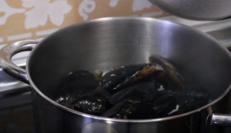 Inilalagay namin ang mussel sa alak sa kalan at hayaan silang pakuluan.